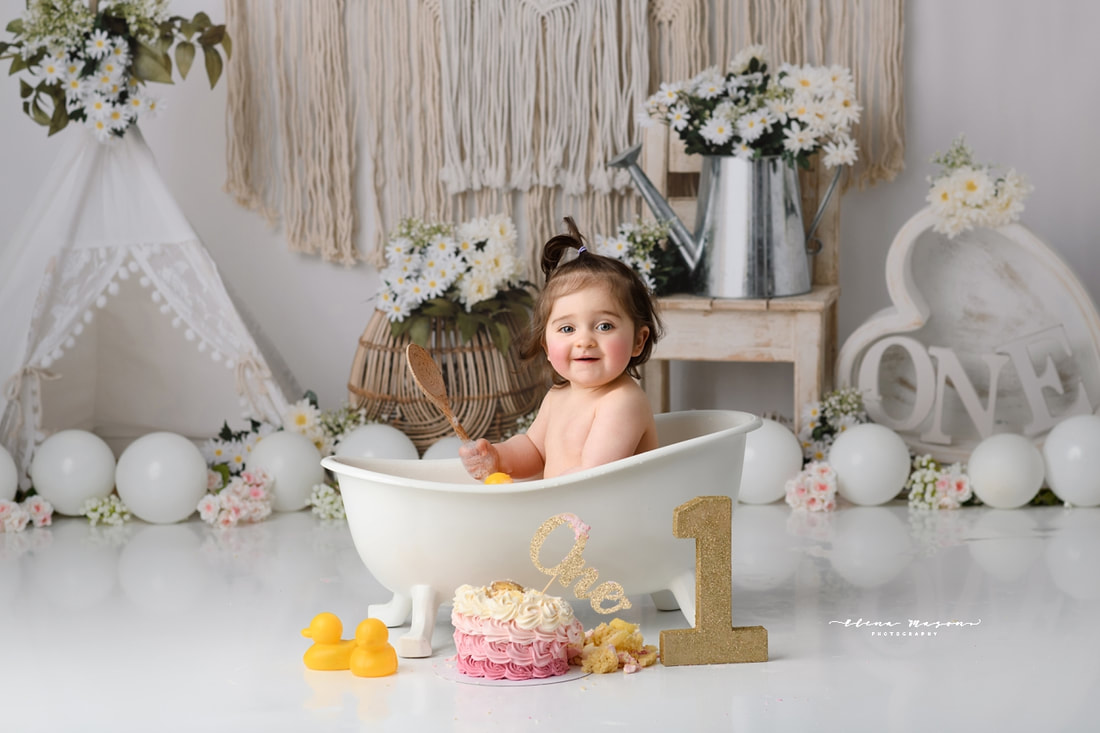 cake smash and splash photo shoot, baby girl having a splash bath in Lisburn photography studio for first birthday 
