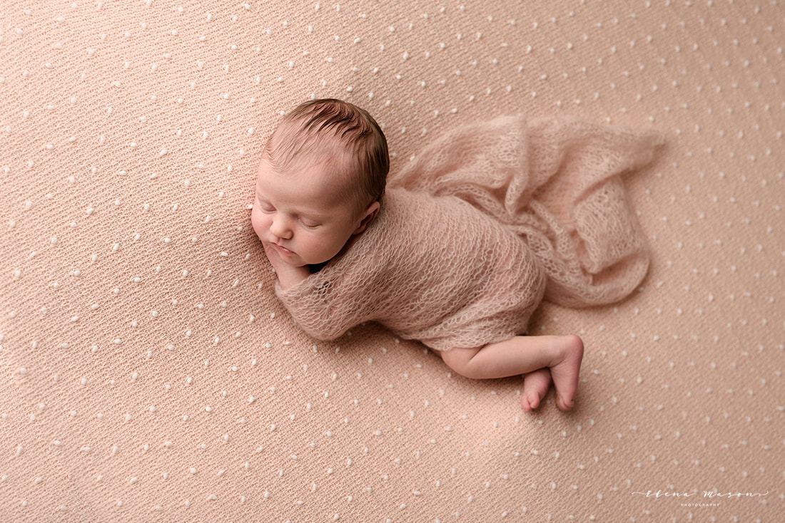 baby on a pink blanket