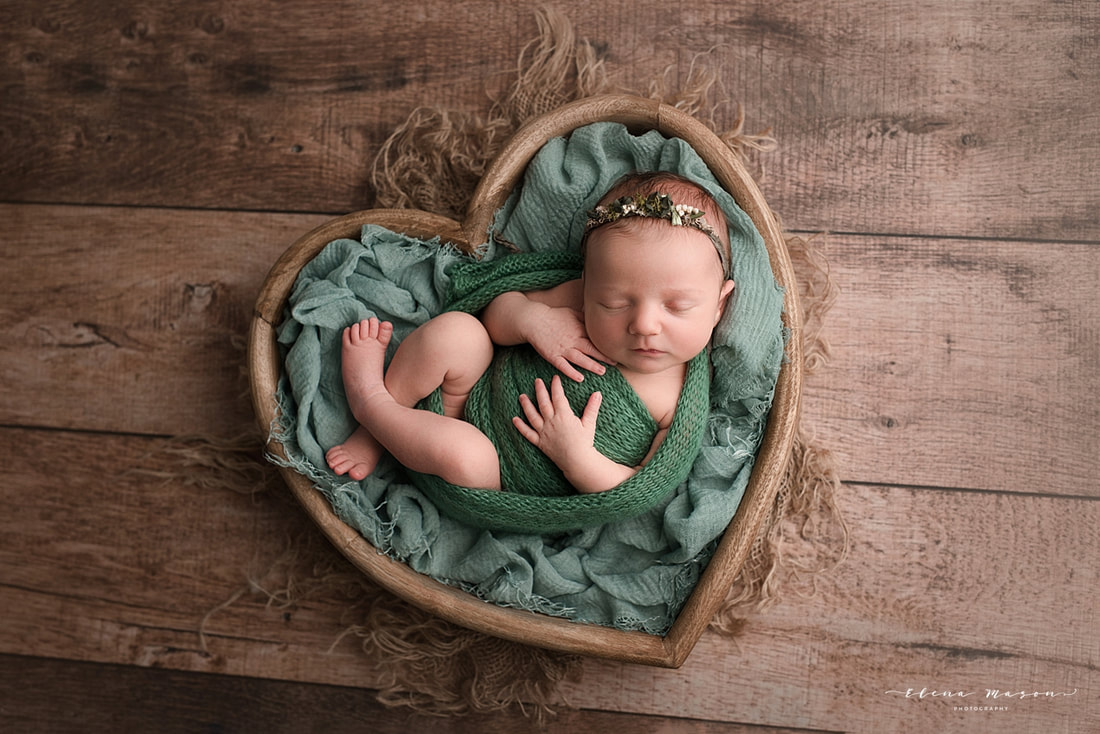baby posed in heart bowl
