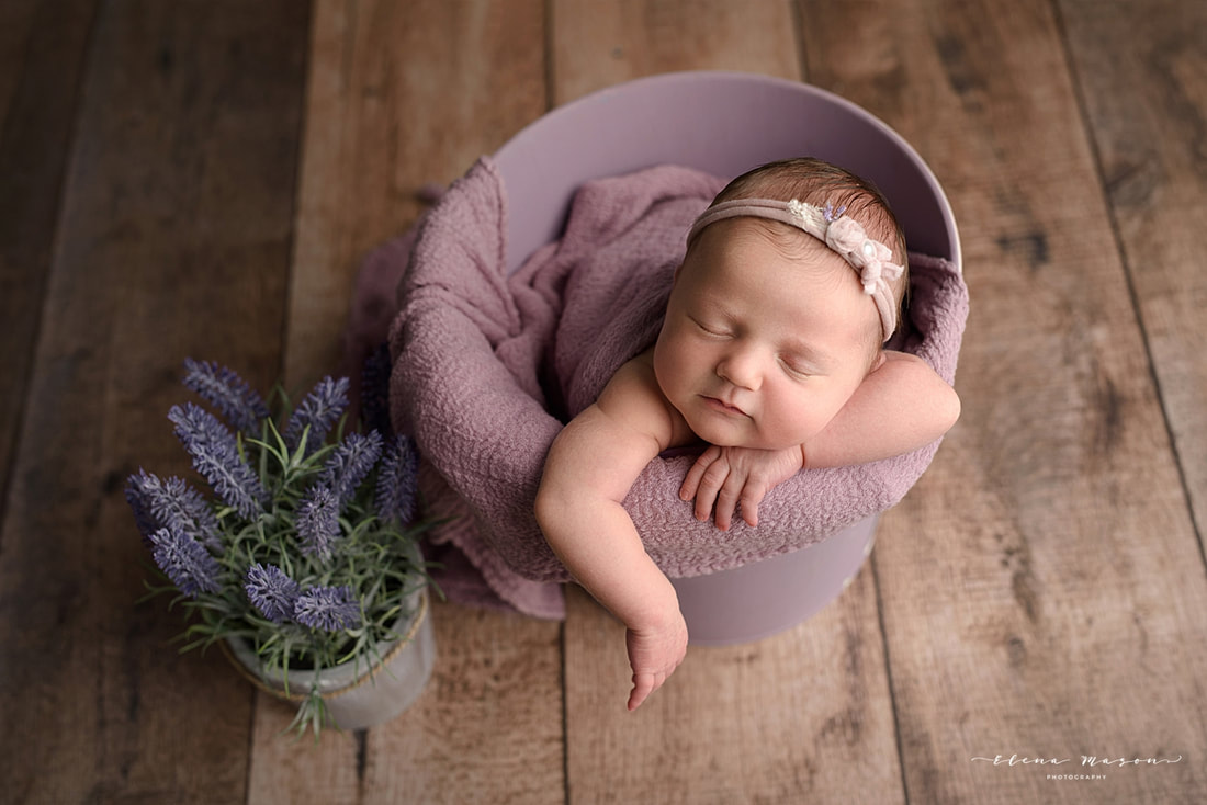 baby in purple bucket with flowers
